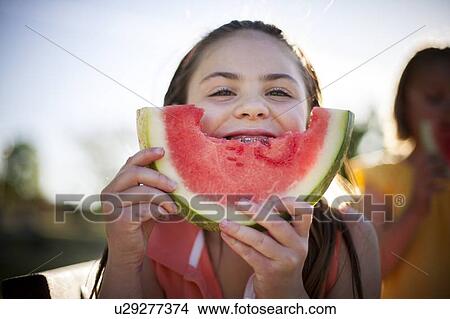 Picture - Smiling girl eating watermelon. Fotosearch