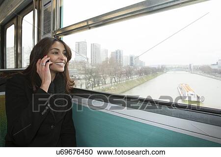 Smiling woman riding train over water View Large Photo Image Stock Image - Smiling woman riding train over water. Fotosearch