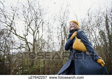 Smiling woman walking in forest View Large Photo Image Stock Photo - Smiling woman walking in forest. Fotosearch