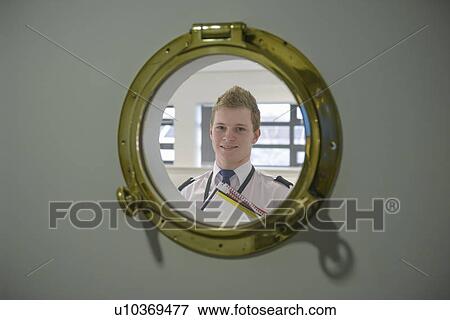 Stock Photo - Student looking through ships porthole. Fotosearch