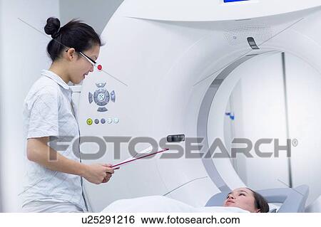 Stock Photograph - Technician with patient in CT scanner. Fotosearch