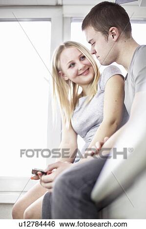 Teenage couple sitting together View Large Photo Image Stock Photograph - Teenage couple sitting together. Fotosearch
