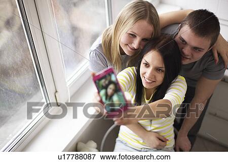 Teenage friends taking picture together View Large Photo Image Stock Photo - Teenage friends taking picture together. Fotosearch
