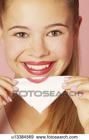 Stock Photo - Teenage girl blotting lipstick on napkin. Fotosearch