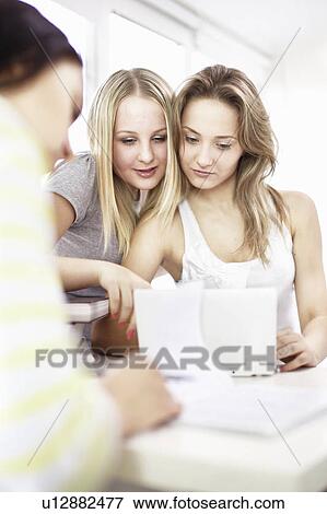 Stock Photo - Teenage girls using laptop together. Fotosearch