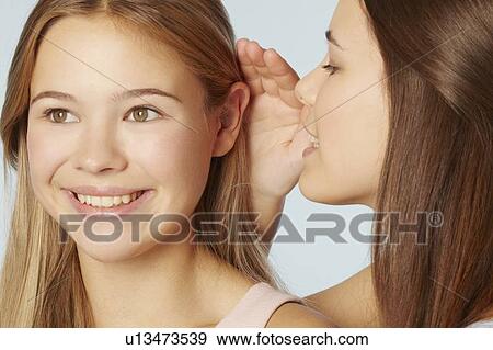 Teenage girls whispering to each other View Large Photo Image Stock Photo - Teenage girls whispering to each other. Fotosearch
