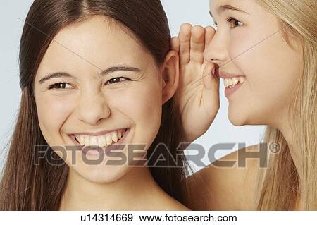 Stock Photo - Teenage girls whispering to each other. Fotosearch