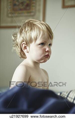 Stock Photo - Toddler boy pouting in bed. Fotosearch