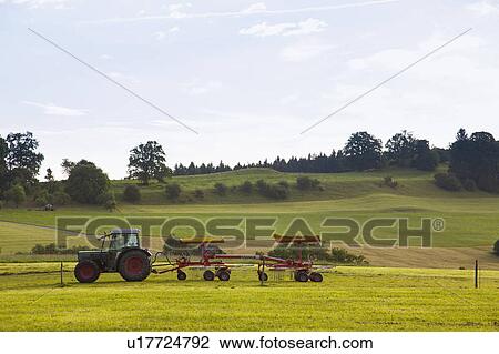 Stock Image - Tractor driving in rural field. Fotosearch