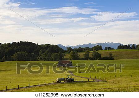 Stock Photography - Tractor driving on dirt road in field. Fotosearch
