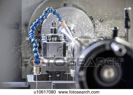 Stock Image - Water spraying on machinery in factory. Fotosearch