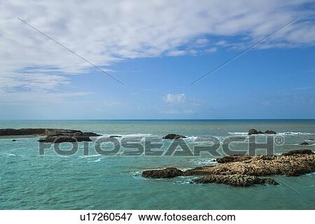 Stock Photo - Waves washing up on rocky beach. Fotosearch