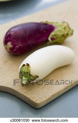 Stock Image - White and purple eggplants on board. Fotosearch