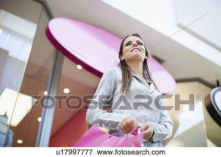 Stock Photo - Woman carrying shopping bag. Fotosearch