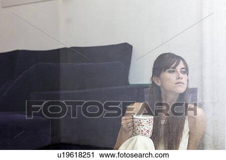 Woman having cup of coffee at window View Large Photo Image Stock Image - Woman having cup of coffee at window. Fotosearch