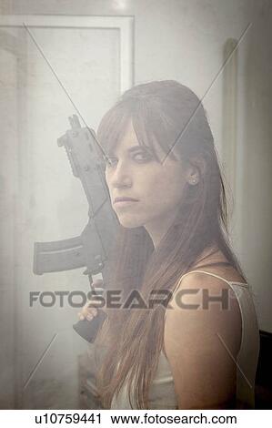 Woman holding machine gun at window View Large Photo Image Stock Image - Woman holding machine gun at window. Fotosearch