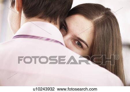 Stock Image - Woman looking over boyfriends shoulder. Fotosearch
