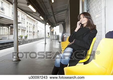 Woman on cell phone at train station View Large Photo Image Stock Image - Woman on cell phone at train station. Fotosearch