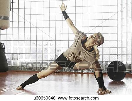 Stock Photo - Woman practicing yoga in gym. Fotosearch