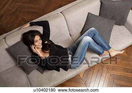 Woman talking on cell phone on sofa View Large Photo Image Stock Image - Woman talking on cell phone on sofa. Fotosearch
