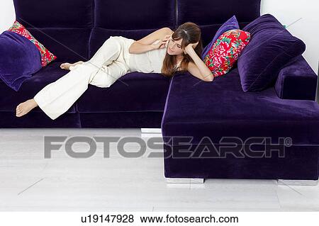 Woman talking on cell phone on sofa View Large Photo Image Stock Photo - Woman talking on cell phone on sofa. Fotosearch