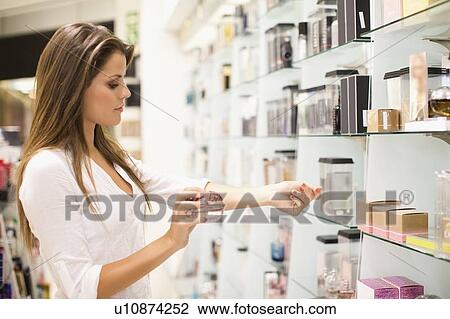Woman trying on fragrances in store View Large Photo Image Stock Image - Woman trying on fragrances in store. Fotosearch