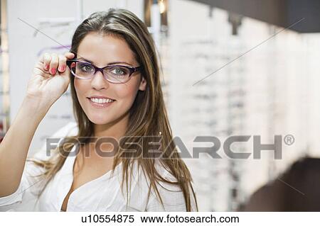 Woman trying on glasses in store View Large Photo Image Stock Photography - Woman trying on glasses in store. Fotosearch