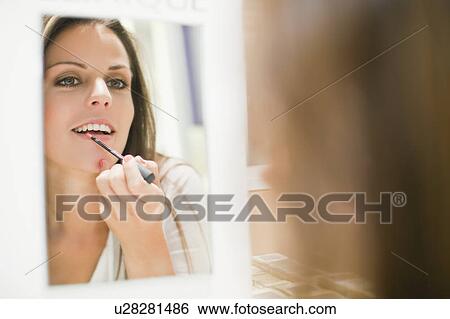 Woman trying on lip gloss in store View Large Photo Image Stock Photograph - Woman trying on lip gloss in store. Fotosearch