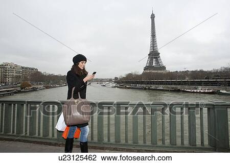 Woman using cell phone on city street View Large Photo Image Stock Image - Woman using cell phone on city street. Fotosearch