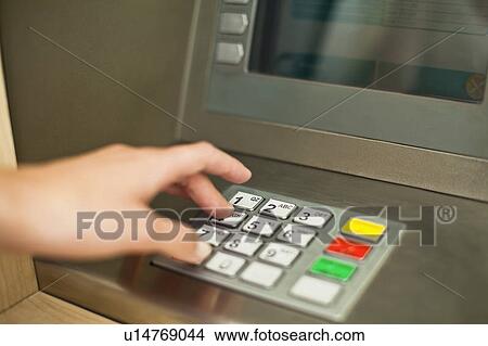 Picture - Woman using keypad on ATM. Fotosearch
