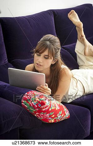 Woman using tablet computer on sofa View Large Photo Image Stock Image - Woman using tablet computer on sofa. Fotosearch