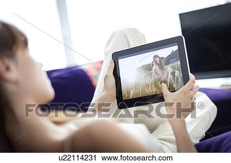 Woman using tablet computer on sofa View Large Photo Image Stock Image - Woman using tablet computer on sofa. Fotosearch
