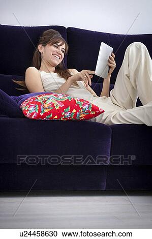 Woman using tablet computer on sofa View Large Photo Image Stock Image - Woman using tablet computer on sofa. Fotosearch