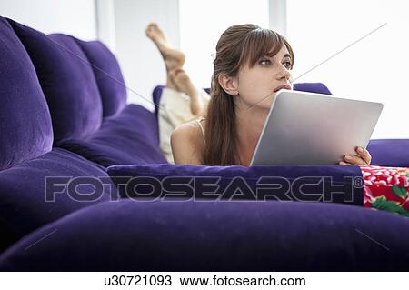 Woman using tablet computer on sofa View Large Photo Image Stock Image - Woman using tablet computer on sofa. Fotosearch