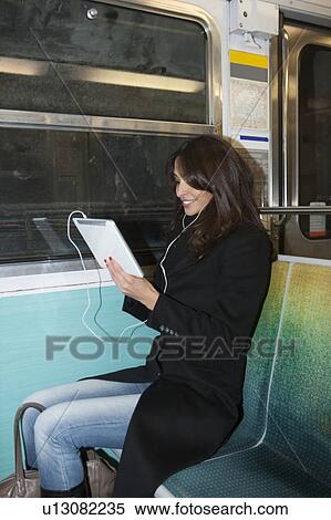 Woman using tablet computer on subway View Large Photo Image Stock Photography - Woman using tablet computer on subway. Fotosearch