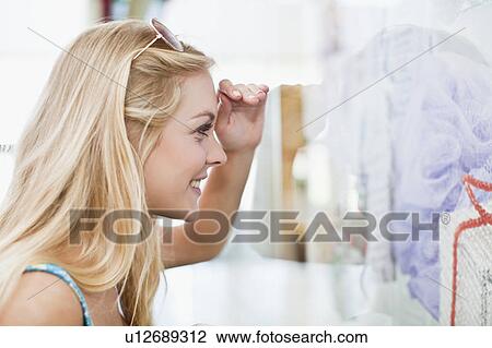 Stock Image - Woman window shopping on city street. Fotosearch