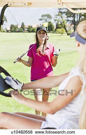 Women playing golf on course View Large Photo Image Stock Photo - Women playing golf on course. Fotosearch
