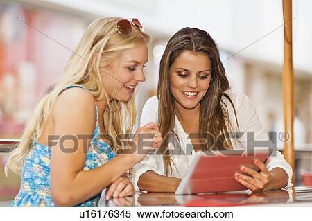 Women using tablet computer at cafe View Large Photo Image Stock Photography - Women using tablet computer at cafe. Fotosearch