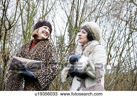 Stock Image - Women walking in forest together. Fotosearch