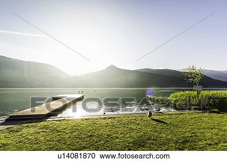 Stock Image - Wooden pier in still rural lake. Fotosearch