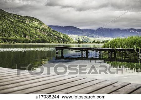 Picture - Wooden piers in still rural lake. Fotosearch