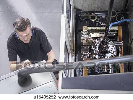 Stock Image - Worker at control panel in factory. Fotosearch