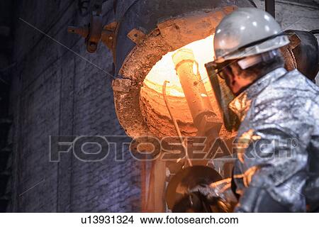 Worker cleaning metal flask in foundry View Large Photo Image Picture - Worker cleaning metal flask in foundry. Fotosearch