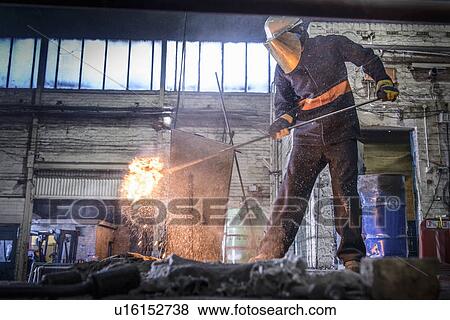 Worker cleaning metal in foundry View Large Photo Image Stock Photo - Worker cleaning metal in foundry. Fotosearch