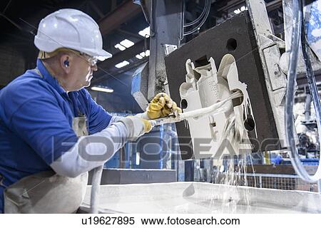 Stock Photography - Worker coating mould in metal foundry. Fotosearch