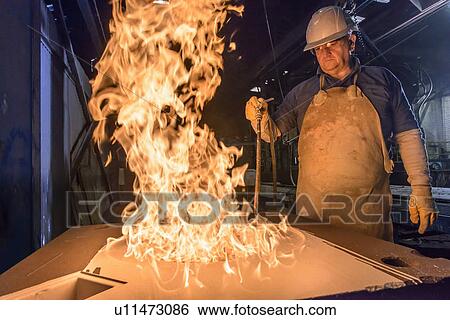 Stock Photograph - Worker curing mould with flames. Fotosearch