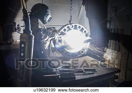 Worker cutting metal in foundry View Large Photo Image Stock Photo - Worker cutting metal in foundry. Fotosearch