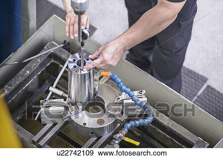 Worker drilling steel rod in factory View Large Photo Image Stock Photo - Worker drilling steel rod in factory. Fotosearch