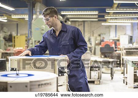 Picture - Worker examining mould in foundry. Fotosearch