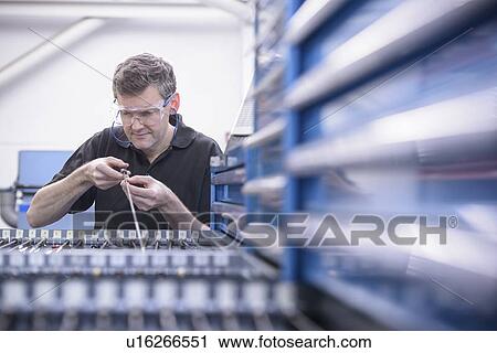 Worker inspecting drill rods in factory View Large Photo Image Stock Image - Worker inspecting drill rods in factory. Fotosearch
